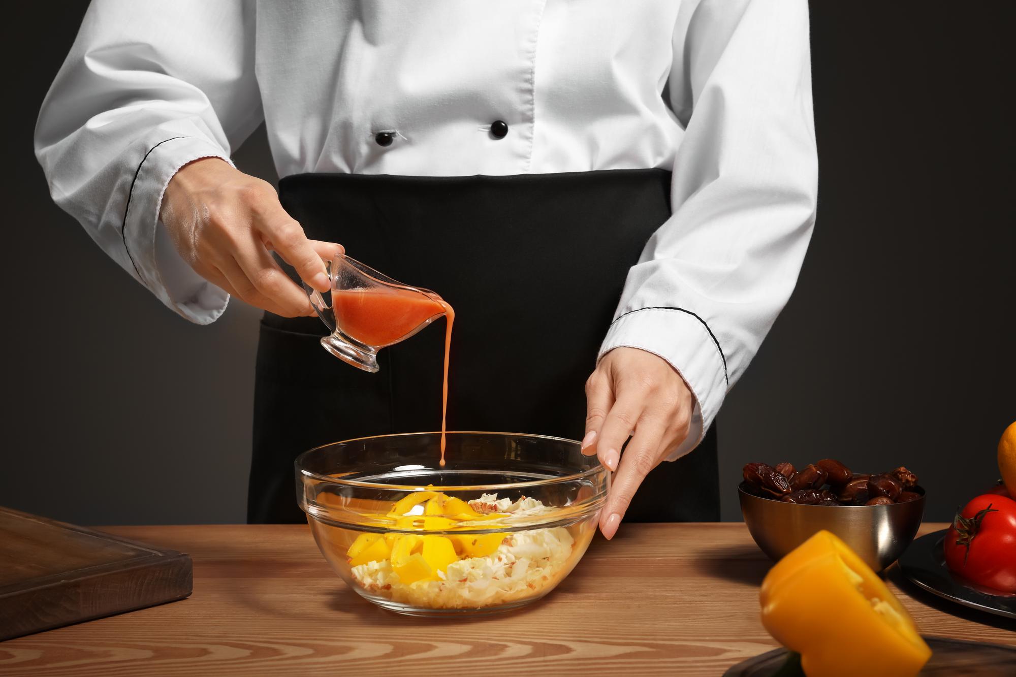 Chef hands finishing a sauce pour